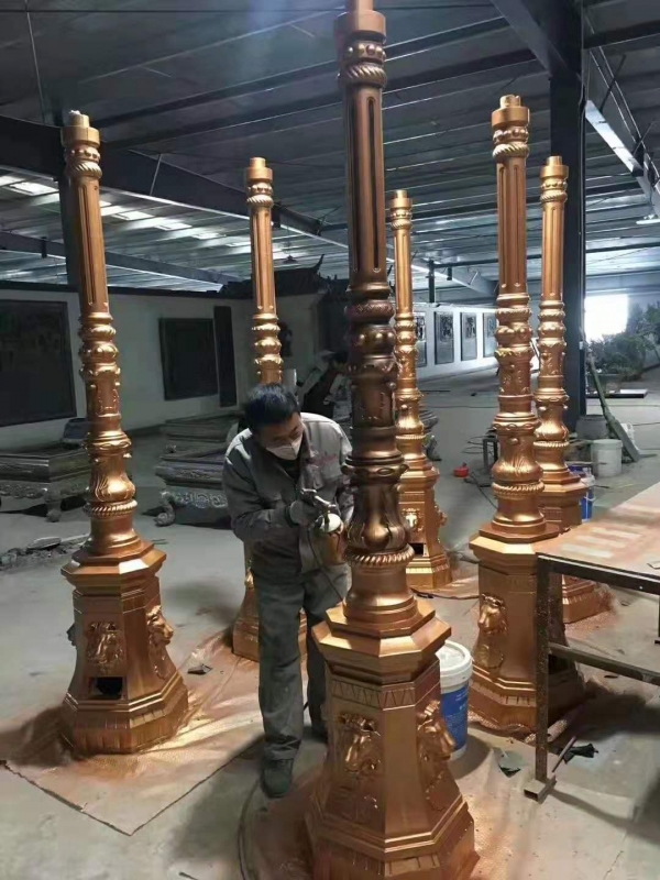 sản phẩm cột đèn đã đúc ra bằng bê tông đang sơn hoàn thiện